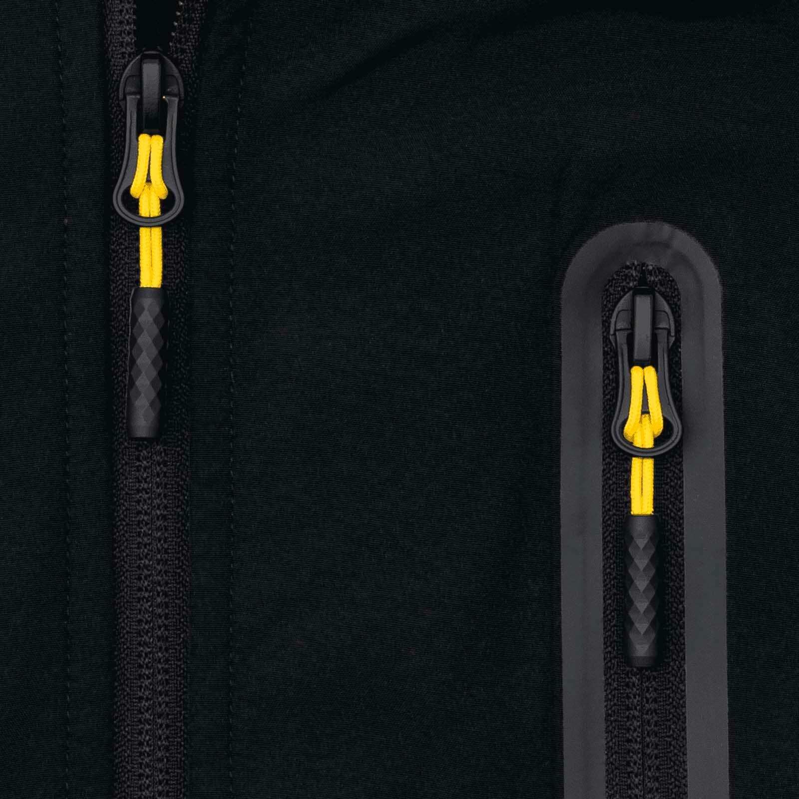 Detailansicht der BVB-Softshelljacke in schwarzgelb mit zwei Reißverschlüssen, gelben Zippern und schwarzem Stoff. Das BVB-Emblem ist nicht sichtbar.