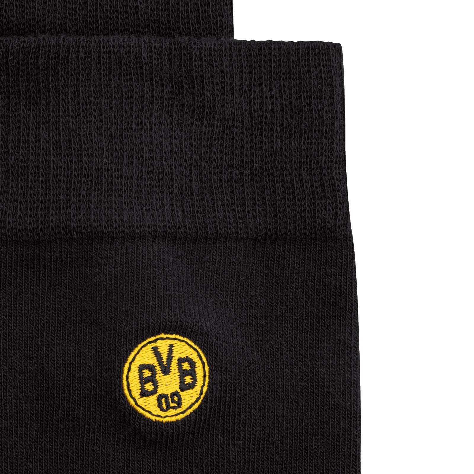 Detailansicht der BVB Business-Socken (2er-Set) 23-24 in schwarz mit aufgesticktem gelbem BVB-Emblem.