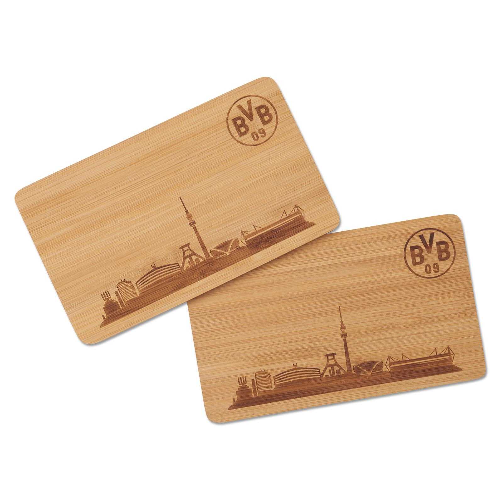 Zwei BVB Frühstücksbrettchen aus Holz in der Vorderansicht mit eingravierter Dortmunder Skyline und BVB-Emblem oben rechts auf jedem Brettchen.