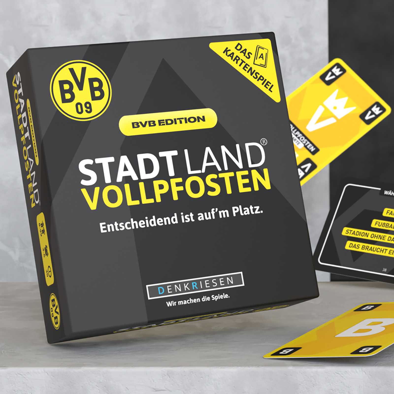 Vorderansicht des BVB Stadt Land Vollpfosten Kartenspiels in schwarzgelbem Design mit BVB-Emblem und sichtbarer Kartenschachtel sowie Spielkarten.