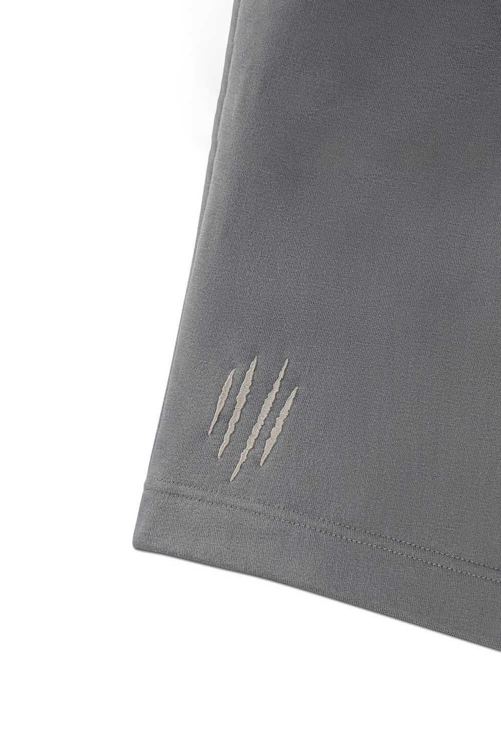 Detailansicht der grauen Sweatpants MR11 mit hellen, krallenartigen Streifen am Hosenbeinabschluss.