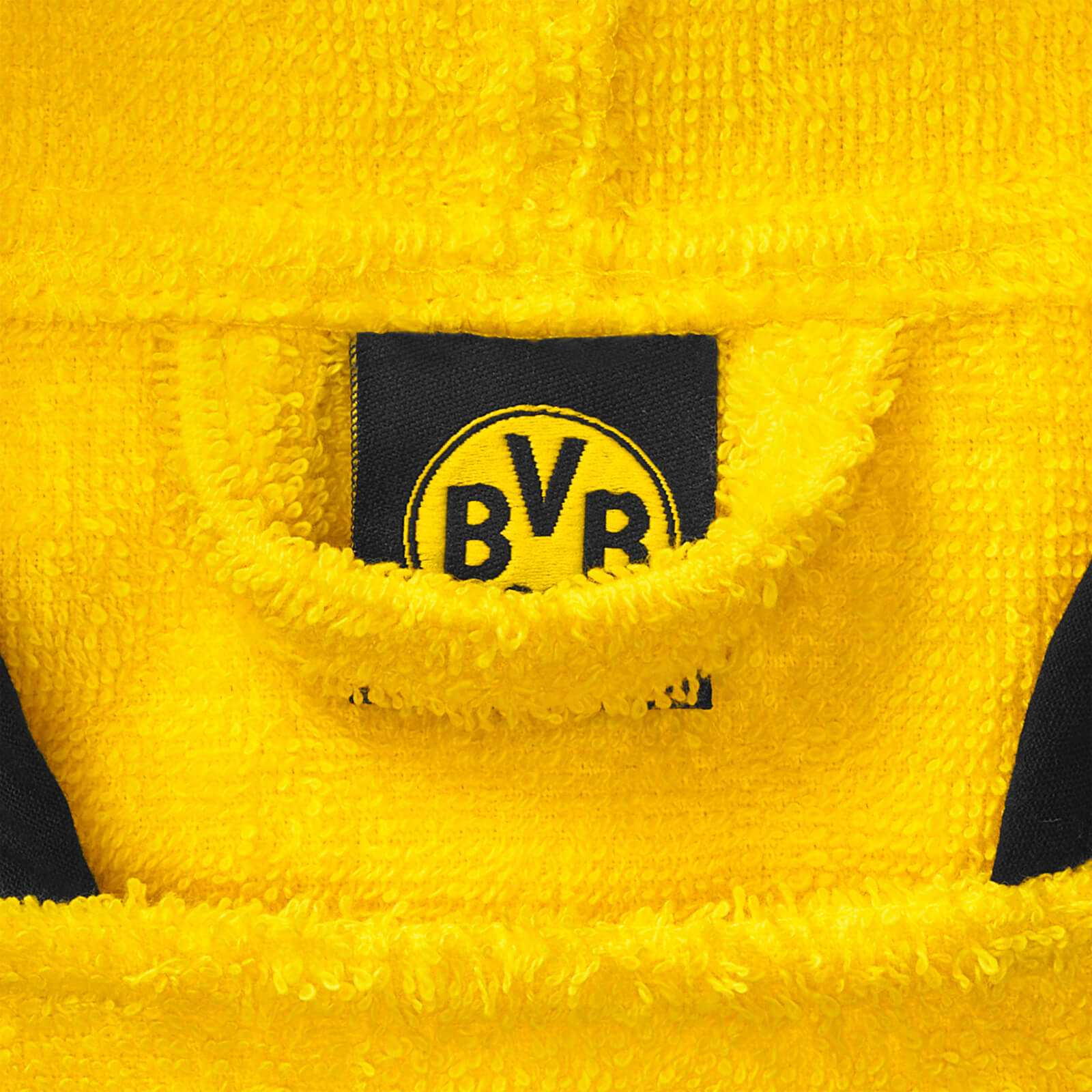 Detailansicht des gelben BVB Badeponcho Emma 46 x 46 cm aus Frottee mit BVB-Emblem auf schwarzgelbem Hintergrund.
