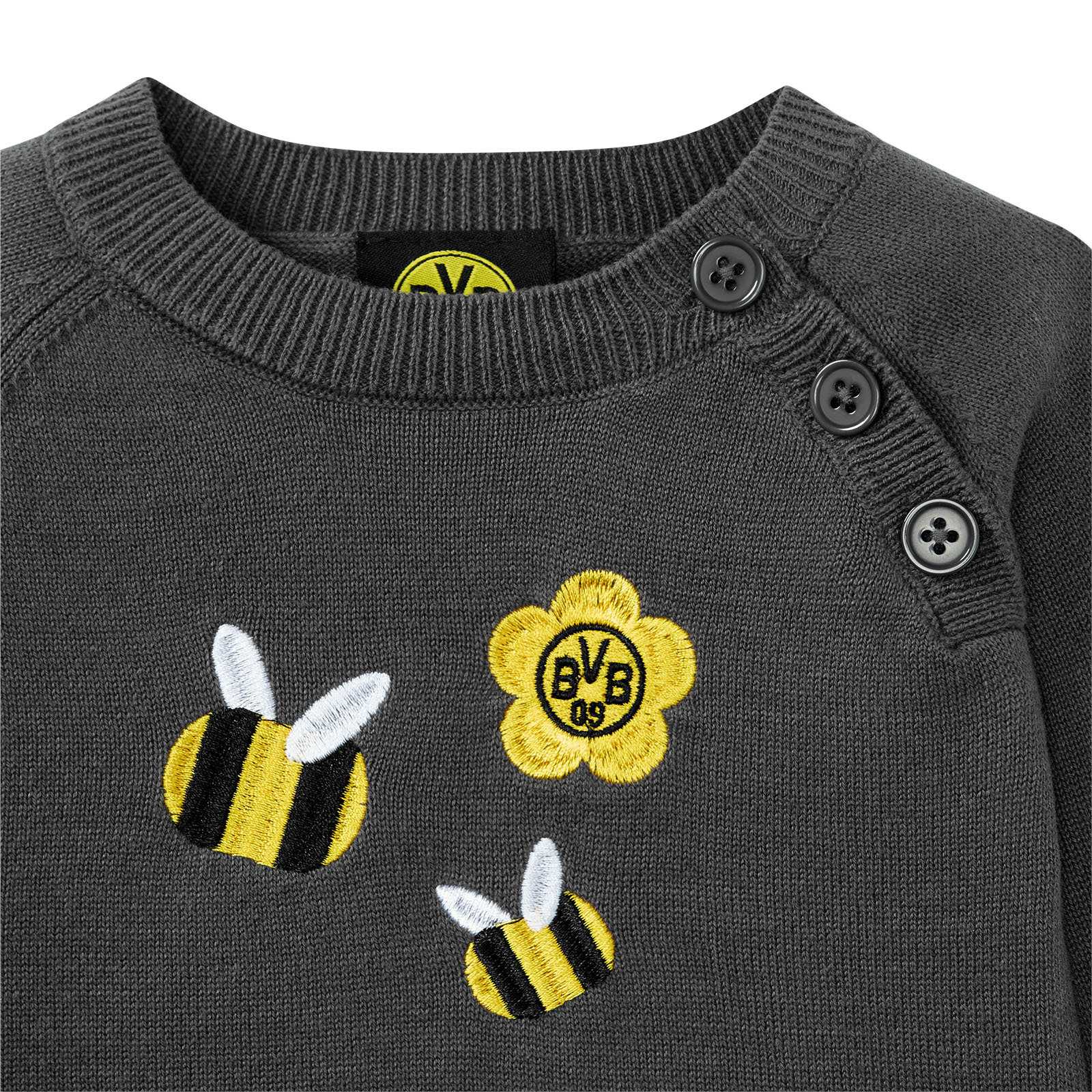 Detailansicht des grauen BVB Strickpullover Baby mit aufgestickten Bienen in schwarzgelb und einer gelben Blume mit BVB-Emblem auf der Vorderseite.