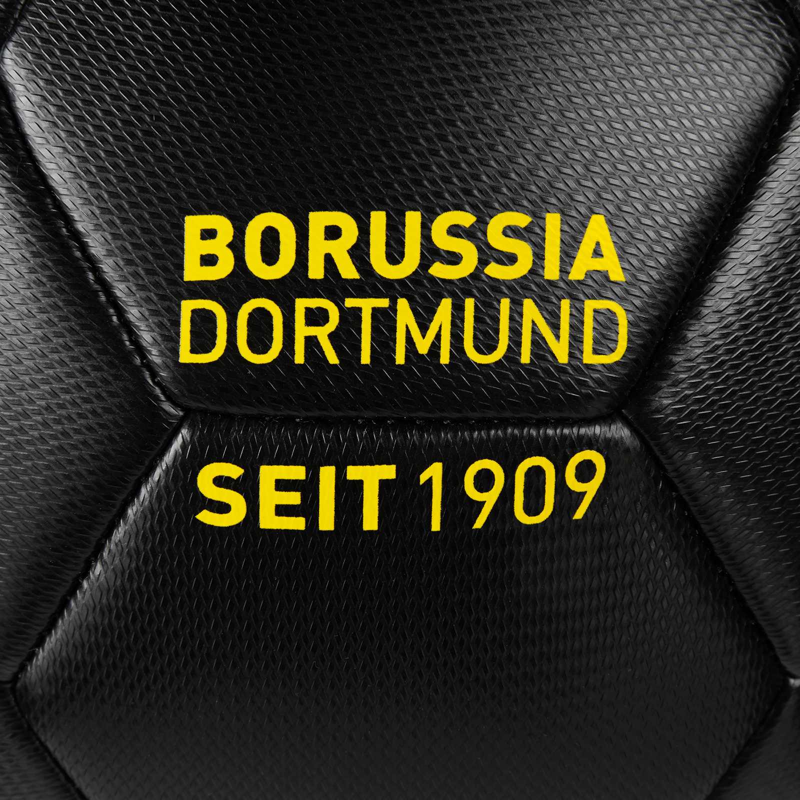 Detailansicht des BVB Ball schwarz embossed mit geprägter Oberfläche und gelber Aufschrift "Borussia Dortmund seit 1909" auf schwarzem Hintergrund.