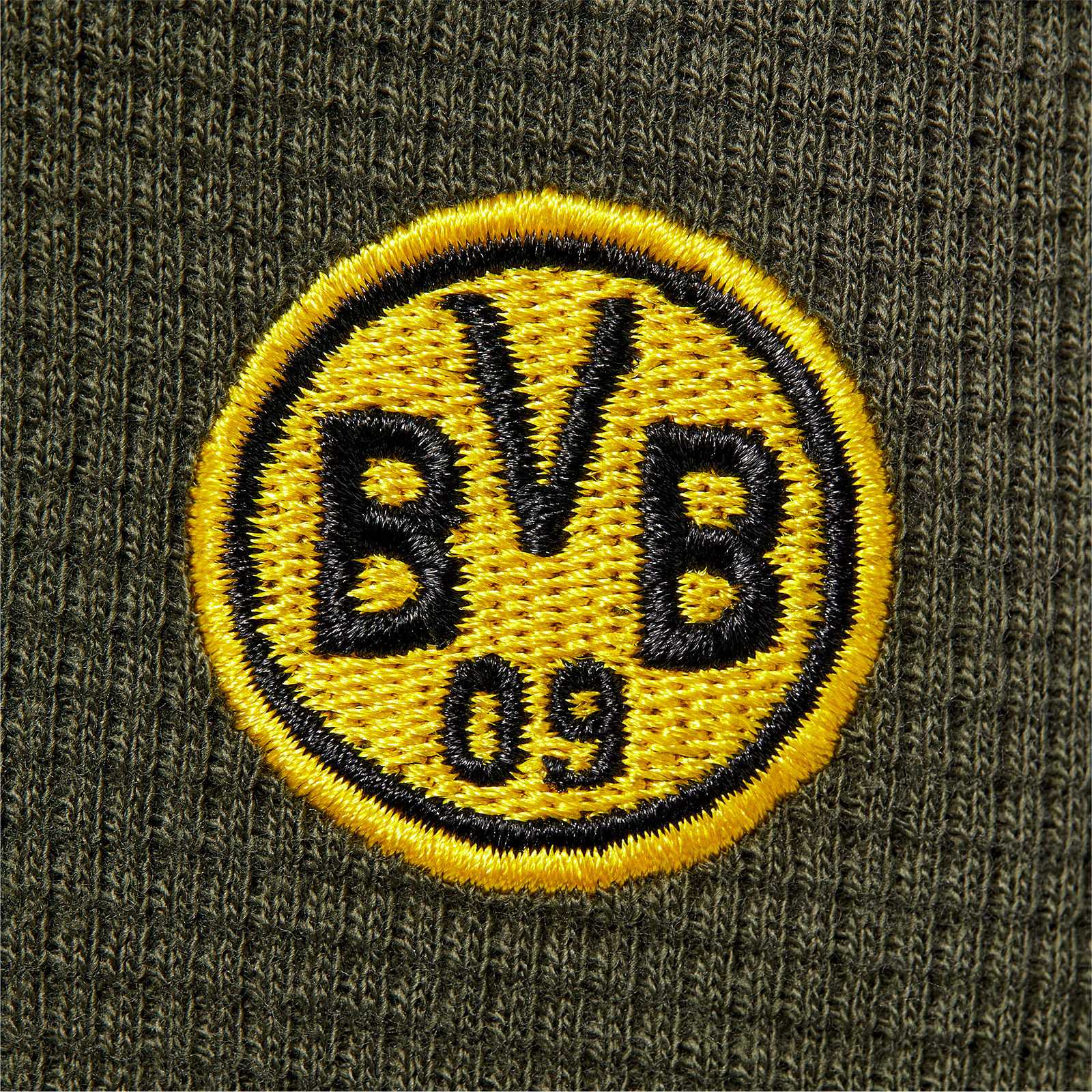 Detailansicht des BVB Jogging-Set Baby mit gesticktem BVB-Emblem in schwarzgelb auf olivgrünem Stoff.