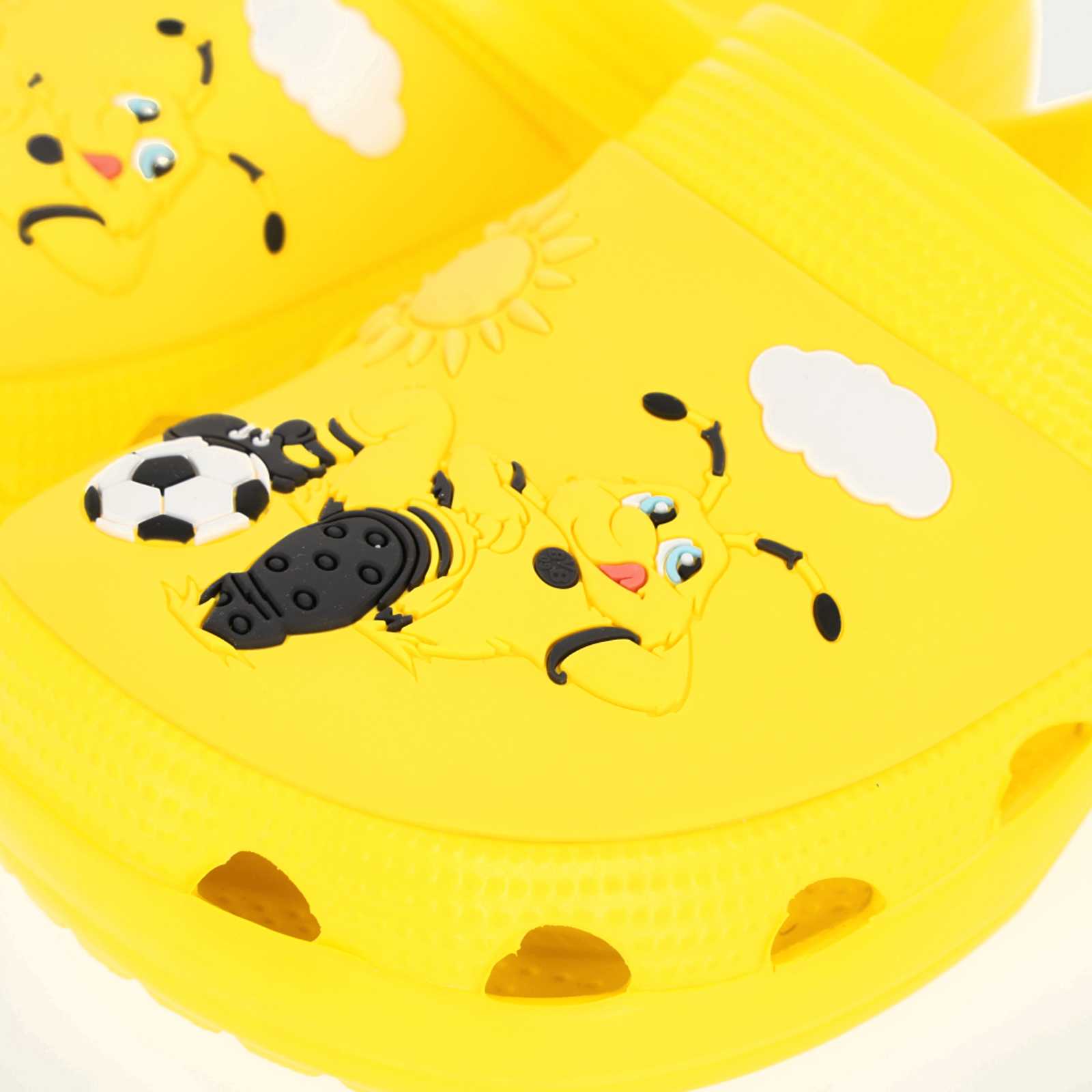 Detailansicht der gelben BVB Clogs Kinder mit EMMA-Motiv, Fußball, Sonne und Wolke auf der Schuhoberfläche.