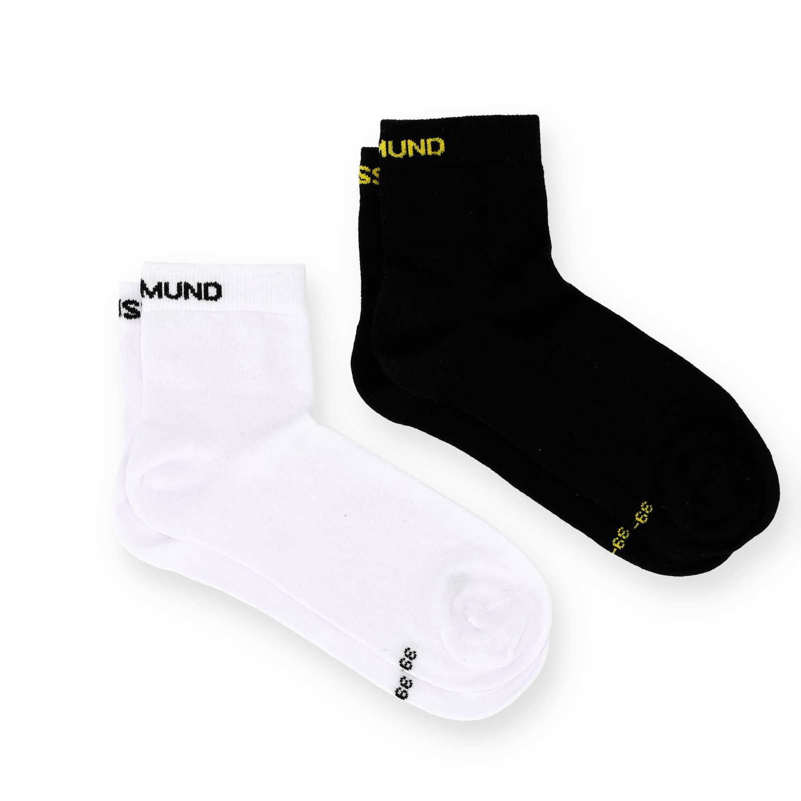 Zwei Paar BVB-Socken. Das weiße Paar hat einen schwarzen Borussia Dortmund-Schriftzug auf dem Spann, das schwarze Paar einen gelben Schriftzug