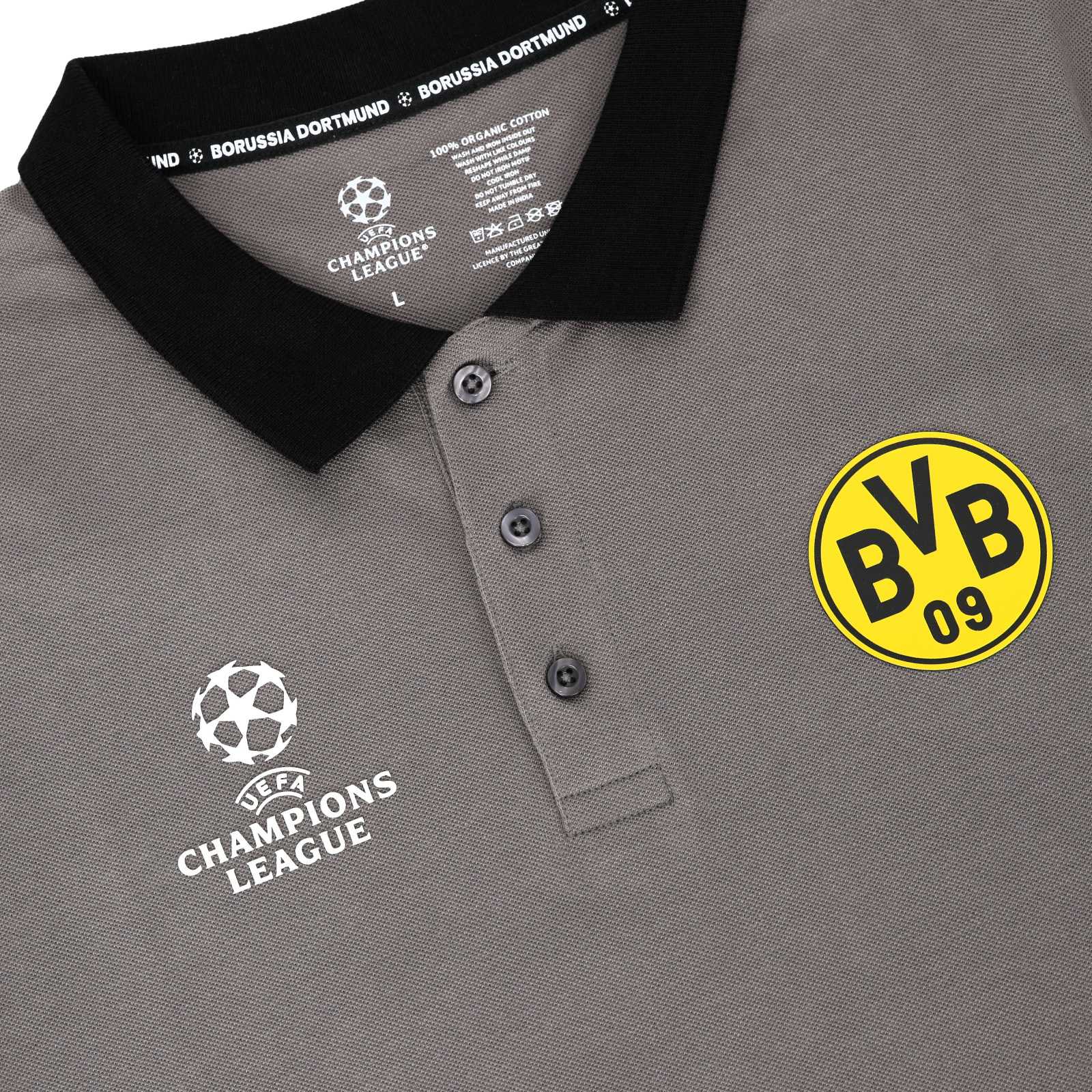 Detailaufnahme des grauen BVB-Shirts mit BVB-Logo und CL-Logo. Mit schwarzem Kragen und Knopfleiste.