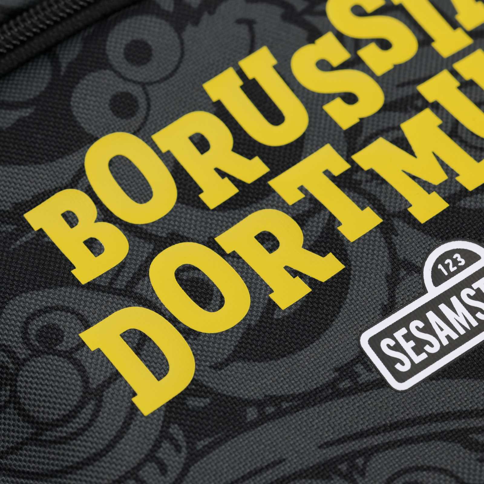 Detailansicht des gelben Borussia Dortmund-Schriftzugs auf der Fronttasche