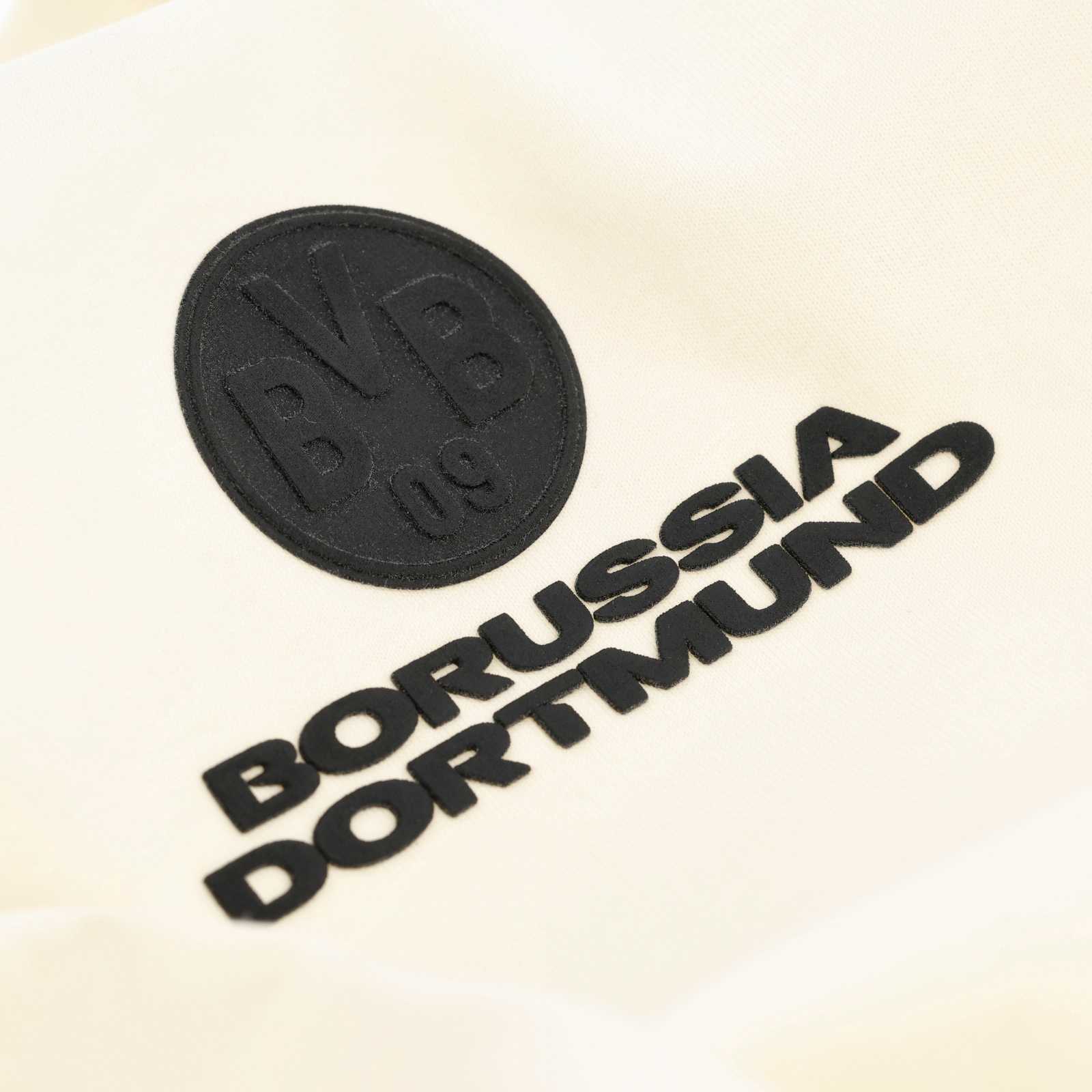 Detailansicht des schwarzen BVB-Rubber-Badges auf der Brust.