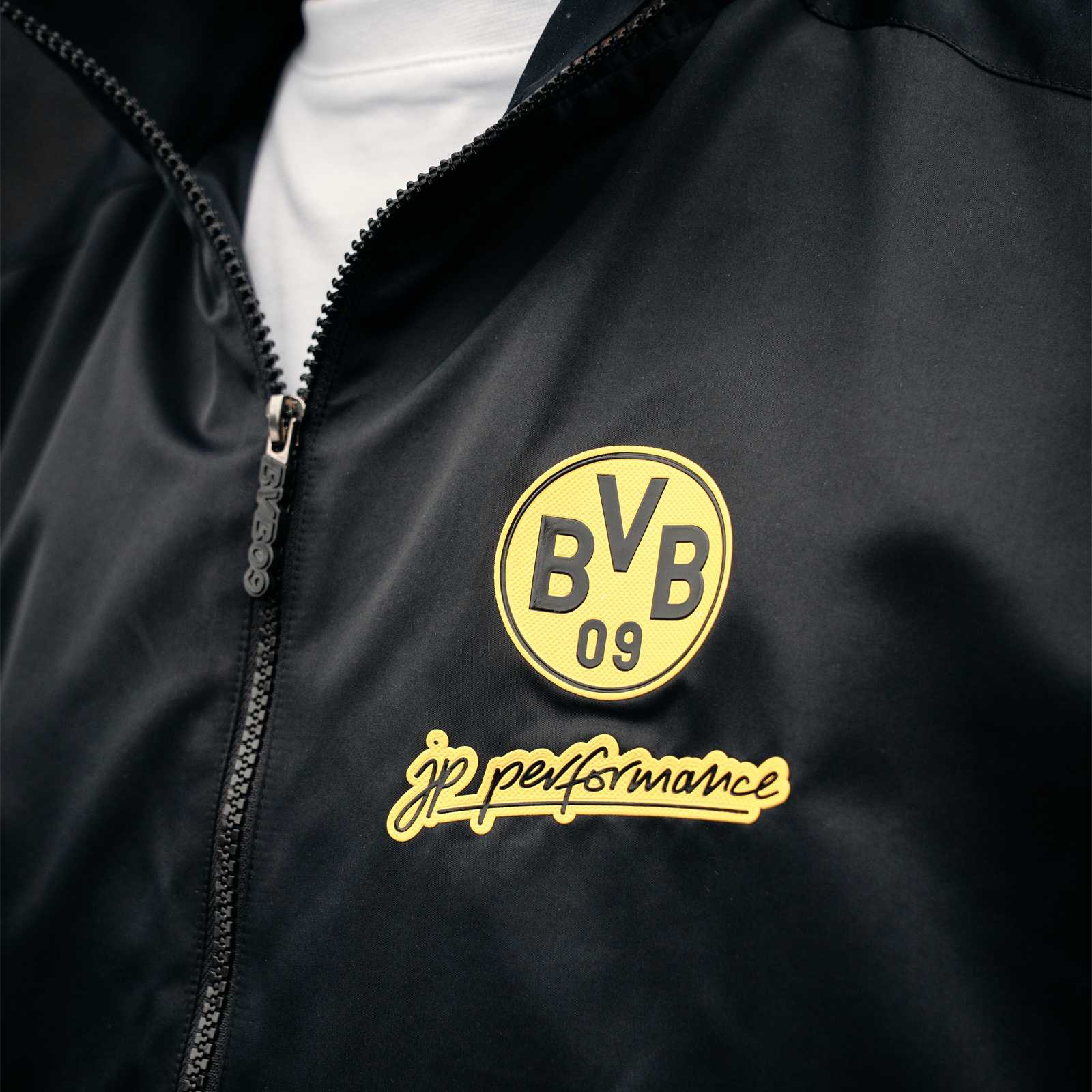 Detailansicht des BVB-Logos und des JP Performance Schriftzugs darunter.