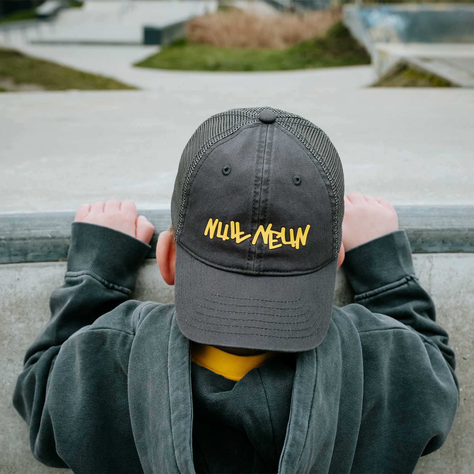 Kleiner Junge steht mit dem Rücken zur Kamera und trägt die graue BVB-Kappe mit Null-Neun-Schriftzug.