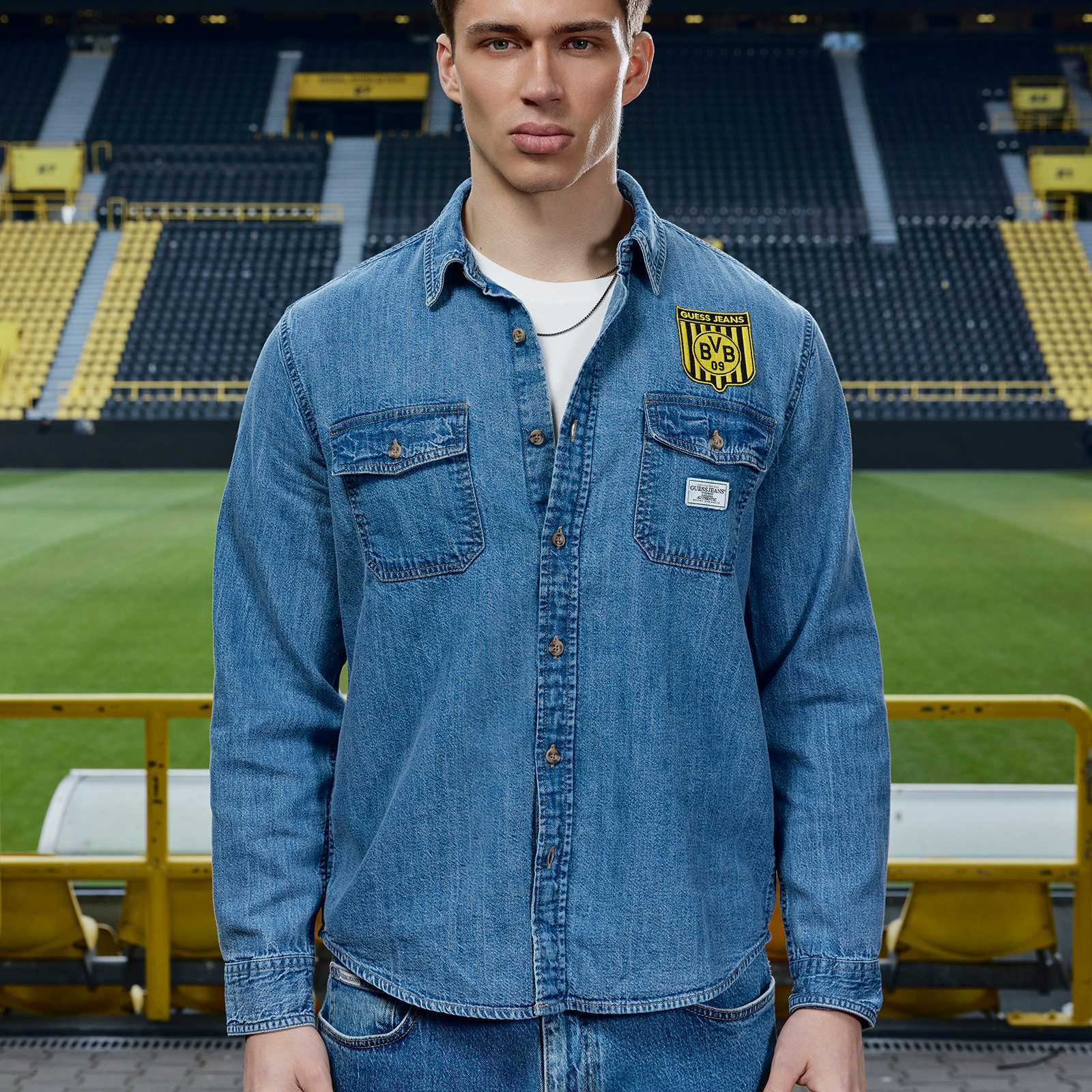 Ein männliches Model im Stadion trägt das Jeanshemd