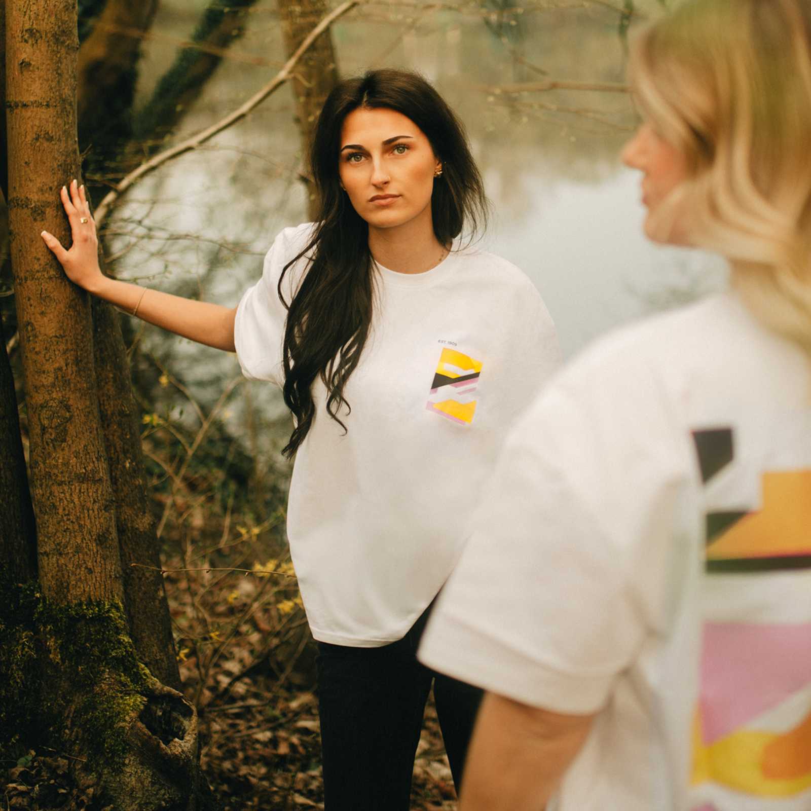 Eine junge Frau steht an einem Ufer und trägt das weiße BVB-Shirt.